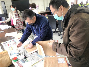 111年特種考試地方政府公務人員考試11日進入第二天試程,昨天到考率略為下降,只有55.75%;試務人員將考卷小心翼翼進行彌封。(圖/文:曹重偉)