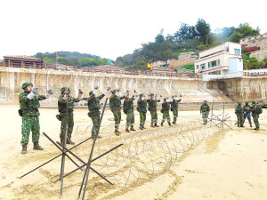 官兵協力設置蛇腹型鐵絲網。(圖:鄭真)