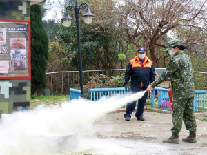 消防隊員指導官兵操作滅火器。(圖:張玄德)