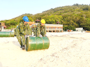 官兵以兩人一組推行油桶。(圖:簡慈儒)