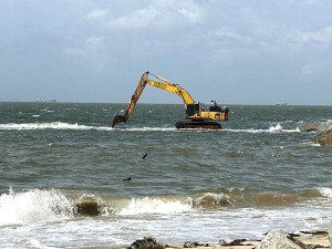 　津沙海堤海岸調適改善工程於外海興建長約125米的離岸淺堤，改善颱風越浪情形，近日怪手停在海外的畫面，讓遊客嘖嘖稱奇。（圖／文：曹重偉）