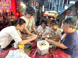 海大學生學習黑冰冰的好手藝、協助愛蘭阿姨準備夏涼市集預備販售的溏心蛋。(圖:海大馬祖校區提供)