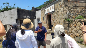 數位發展署青年T大使計畫結合中小企業總會推動北竿塘岐數位導覽計畫,地方耆老周起財先生為大使們說故事。(圖:社造中心提供)