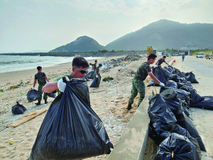　官兵協助將打包垃圾集中。（圖：楊子賢）