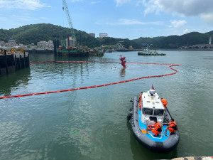 　「台港13302」拖駁船今天上午10時發生傾斜及沉沒，環資局同仁攜大量海污專用攔油索前往佈放，在海巡隊小艇配合下先拉起油污控制線。（圖：環資局）