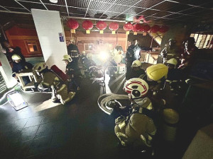 春節在即,消防局1日晚舉辦春節火災搶救演練,模擬二樓商家失火延燒,消防人員架設水線進入滅火,過程緊湊逼真。(圖/文:曹重偉)
