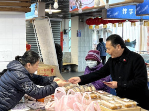 縣長王忠銘4日在山隴獅子市場發送龍年小福袋,祝賀鄉親新年快樂。(圖/文:馮紹夫)