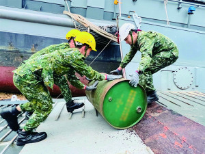 官兵將油桶搬至船上。（圖：林雅琪）