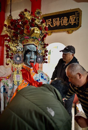 　東引鄉「白馬尊王」遶境擺暝活動即將在正月十七盛大登場，廟委會幹部齊聚天后宮為保長公等神偶換上乾淨衣裳，揭下遮住眼睛的元寶，開啟慶典活動的序幕。（圖／文：陳其敏）