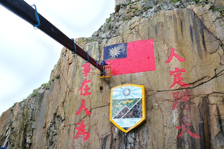 　西引島石刻「人定勝天」標語及國旗圖案進行油漆，以提升戰地文化景觀的精神。（圖／文：陳其敏）