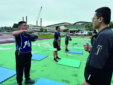 操作壺鈴平舉。（圖：陳昱軒）