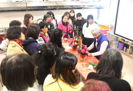 　婦女會「綻放新春、關懷無限」春節鮮花研習眾多學員參與，邀花藝講師萬啟秀指導「花開富貴、金銀滿堂」，成品金光閃閃、亮麗奪目。（圖／文：曹重偉）