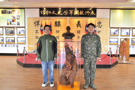 　退伍老兵周伯竑贈送木雕作品給東引指揮部，由指揮官馮少毅少將代表接受。（圖：東指部）