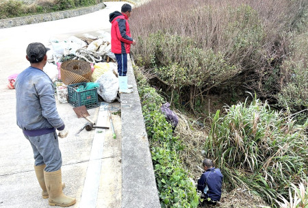 　東引小紫澳附近路段遭濫倒廢棄物，污染行為人28日上午到場進行清理。（圖／文︰陳其敏）