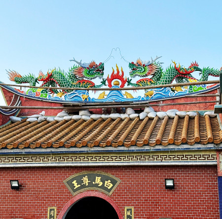 嘉義畫師林當權為東莒大浦白馬尊王廟屋頂上的雙龍重新彩繪。(圖/文:蔡夢玲)