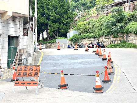 工務處施作防滑路面卻造成更多機車騎士打滑,工務處緊急圍起道路準備進行改善。(圖/文:馮紹夫)