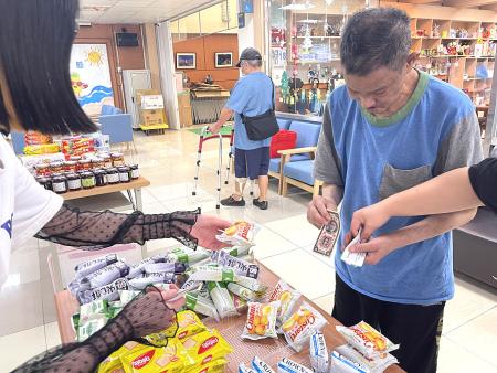 長輩們開心挑選兌換商品，現場氣氛溫馨熱絡，如同迷你市集。（圖／文：褚又慈）