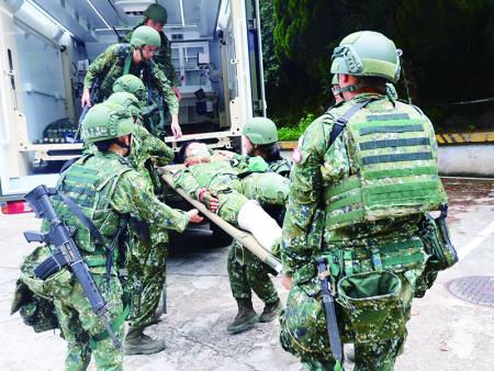 官兵將傷患抬上救護車。