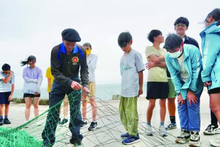 今年6月舉辦的草繩編結藝術共創工作坊,中山國中的學生們在老漁民黃鵬武的引導下,現場認識定置網的構造與運作原理。(圖:文化處提供)