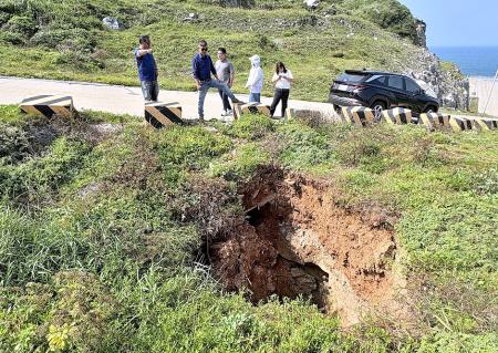 東引的「峰虎角」附近路段出現深約三至四公尺的坑洞，鄉公所已緊急僱請廠商進行修補，並提醒用路人不要靠近警示區域。（圖／文：陳其敏）