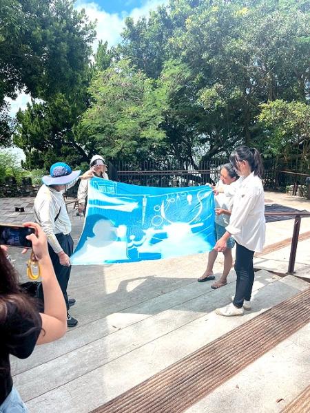 五三迴藝據點舉辦藍曬體驗活動,參與者在藍天海景與軍事風情中互助合作、氣氛熱絡,感受藝術魅力與新鮮體驗。(圖:五三迴藝據點)