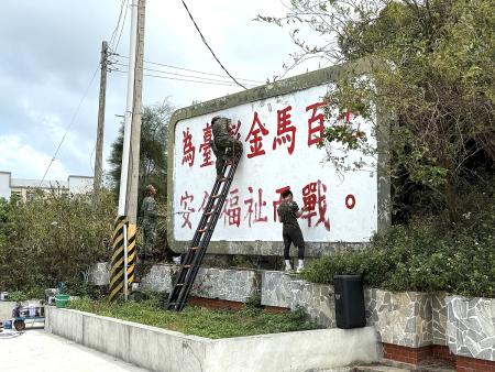 為迎接年度馬拉松賽事,縣府文化處攜手馬防部進行軍事標語翻新塗裝作業。(圖/文:王致潔)