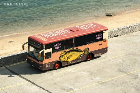《島魚行旅》/藝術家:鄒駿昇, 本車體設計以黃魚罐頭作為視覺符號,象徵馬祖島嶼的風味與記憶。罐頭既是保存食物,也是一種封存時光的隱喻。配色上,母魚車以暖紅呈現人文溫度,公魚車以冷綠呼應山海沉靜,兩者共同描繪出隨時間釀成的色彩旅程,將馬祖轉化為一座可移動、可品味的文化島嶼。 展點:南竿北竿藝術島展期依特定專車路線, 非展期間依連江縣南北竿公車路線移動