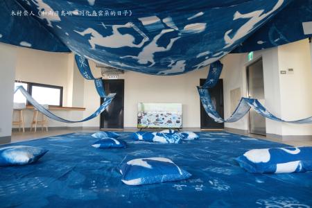 《和兩座島嶼一同化為雲朵的日子》／藝術家：木村崇人， 透過在東莒國小與男木島的中小學舉辦的藍曬顯影布工作坊，藝術家和兩島的孩子與居民們共同創作出一只大型風箏，風箏上承載著孩子們如雲朵般的身影，以及他們的夢想與希望；而在地面上，則留下了大人們獻給未來世代的盼望與祝福。那麼，當我們跨越族群與文化的邊界時，對於未來，我們懷抱的是怎樣的期望呢？此作品延續木村的系列作品《化為雲朵的日子》，以水的循環為靈感，希望身為人類的我們能如雲一般，成為地球不可或缺的一部分。 展點：東莒猛澳港務大樓