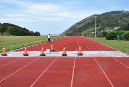 東湧運動公園跑道局部出現隆起與裂縫，鄉公所進行修補。（圖／文：陳其敏）