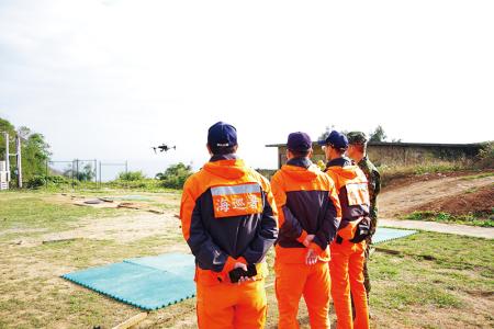 教官帶領海巡人員及官兵實際操作無人機。