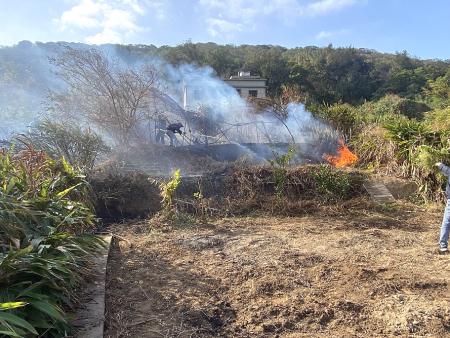 雜草起火冒煙，消防人員與義消、村民到場即時灌救，火勢迅速受控。（圖／文：鄭禮頤）