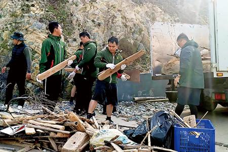 官兵協助搬運漂流木。