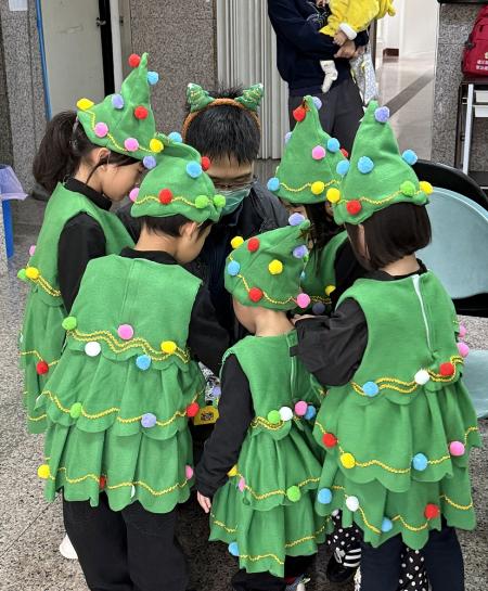 東莒幼兒園愛心班孩子們化身小小聖誕樹走上街頭報佳音，抵達定點後隨著音樂跳舞，以童真的笑容為節日前夕增添溫暖氣氛；衛生所主任被小小聖誕樹包圍，畫面相當有趣。（圖／文：蔡夢玲）