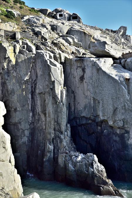 東引島陡峭險峻海岸地形是軍事戰略上的重要屏障，在岩石上繪製的假射口則具有視覺欺敵的巧思。（圖／文：陳其敏）