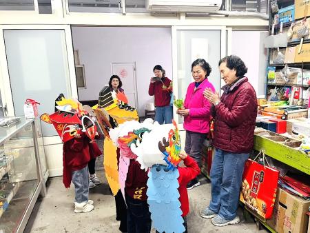 東莒國小附設幼兒園愛心班以舞龍舞獅沿街拜早年，並為店家進行「咬青／採青」儀式、送上發糕祝賀，童音齊喊吉祥話，現場掌聲不斷。（圖／文：蔡夢玲）