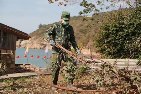 官兵進行道路周邊樹枝清理。