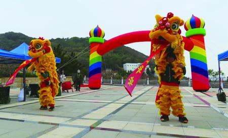 舞獅上肩放下對聯賀新春。