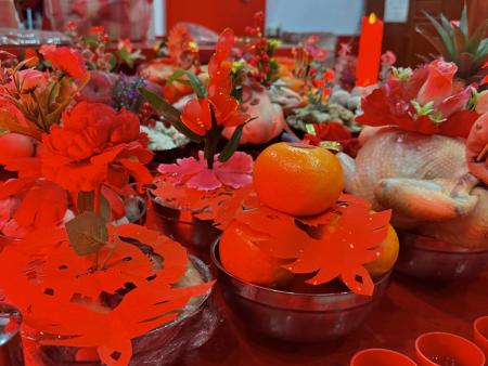 鄉親們開心地與孩子們拿著剪花合影，並將孩子們送上的紅紙剪花加入各自準備的供品中，供桌上可見一組組結合剪花作品的擺設，成為今年臨水夫人擺暝的特別畫面。（圖／文：蔡夢玲）