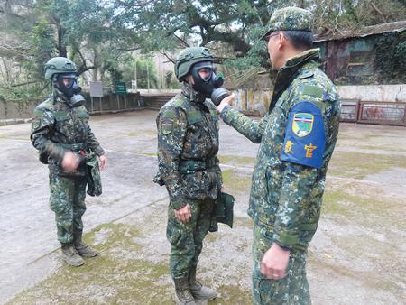教官檢查官兵面具密合度。
