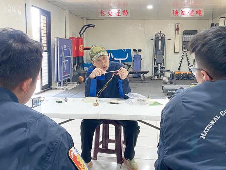 教官示範接線操作，帶領官兵了解修繕流程與基本原理。