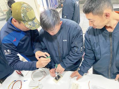 官兵練習電線接線操作，學習辨別電線顏色與插座孔位對應。