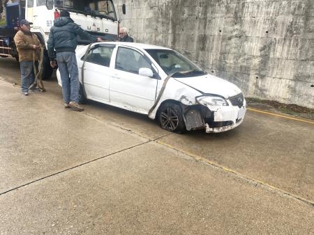 碧園路段一輛小轎車疑因天雨路滑自撞路燈，路燈被撞至連根拔起，車頭受損變形，所幸無人受傷。（圖／文：鄭禮頤）