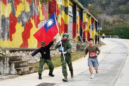 官兵全副武裝揮舞國旗，展現高昂士氣。