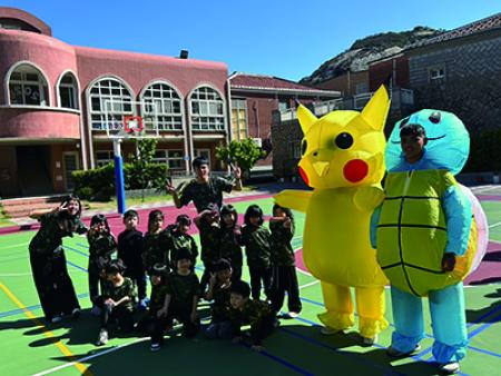 官兵扮演玩偶與幼稚園兒童一同遊戲。