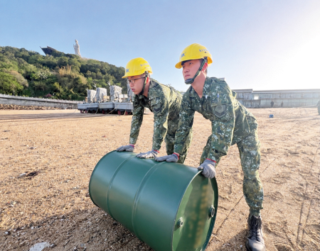 官兵協力將油桶上船，展現團結向心精神。