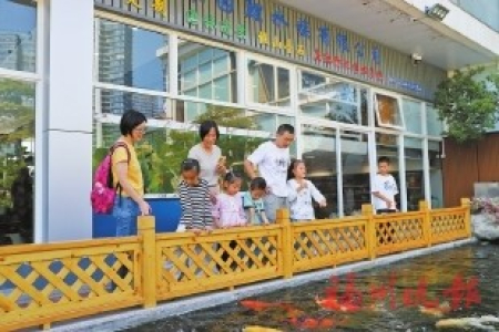 ▲遊客在館內投喂金魚。
