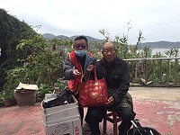 華山基金會贈送年菜給地區孤老,由義工郭鎮輝先生陸續發送。(圖:華山基金會)