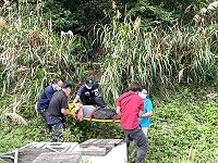 　一部轎車由環島北路路肩邊坡滑落近30公尺山谷，消防單位費了九牛二虎之力才把受傷駕駛抬下山。（圖／文：陳鵬雄）