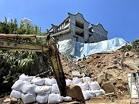 　中山國中辦公大樓地基淘空持續加強沙包堆放，邊坡防水布面積再加大。（圖／文：陳鵬雄）