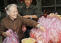 　山隴村新街有兩戶人家同時選擇昨天吉日進行灌頂，圖中新屋屋主正在打點分送給親友的蛋糕。（圖／文：張登傑）
